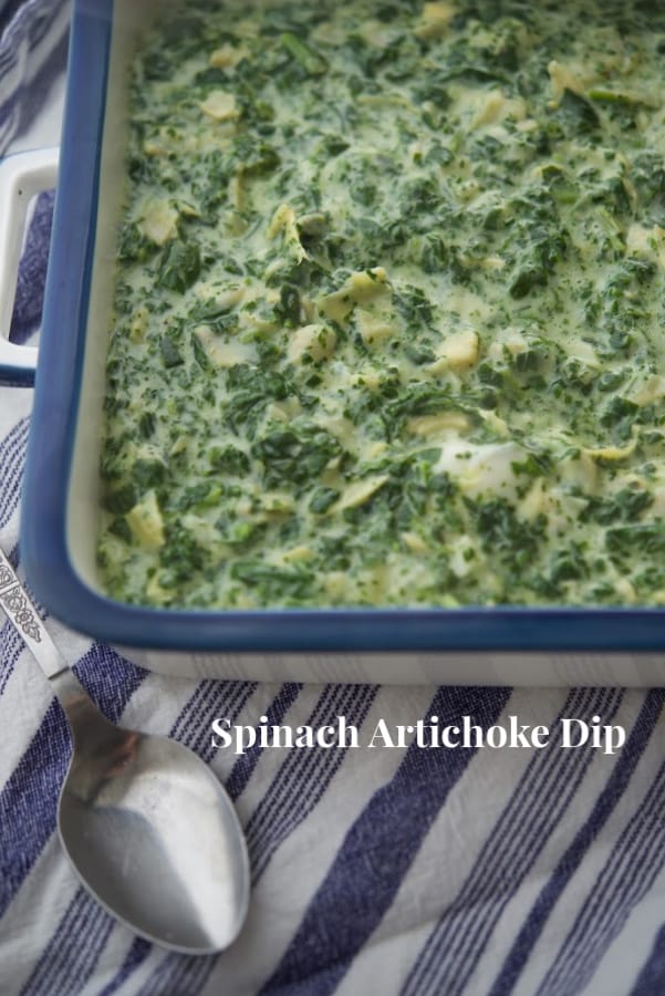Spinach artichoke dip in a blue baking dish. 