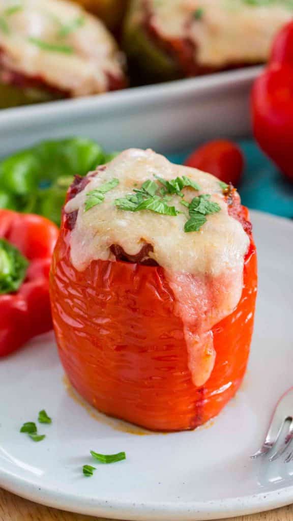 A close up of food on a plate, with Bell Pepper and Stuffed peppers