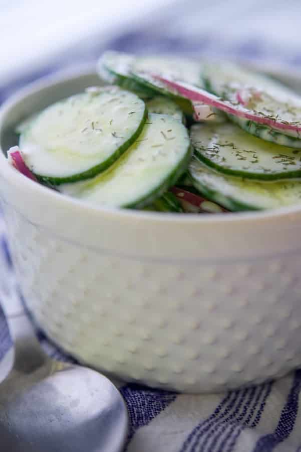 A bowl of food, with Salad and Cucumber