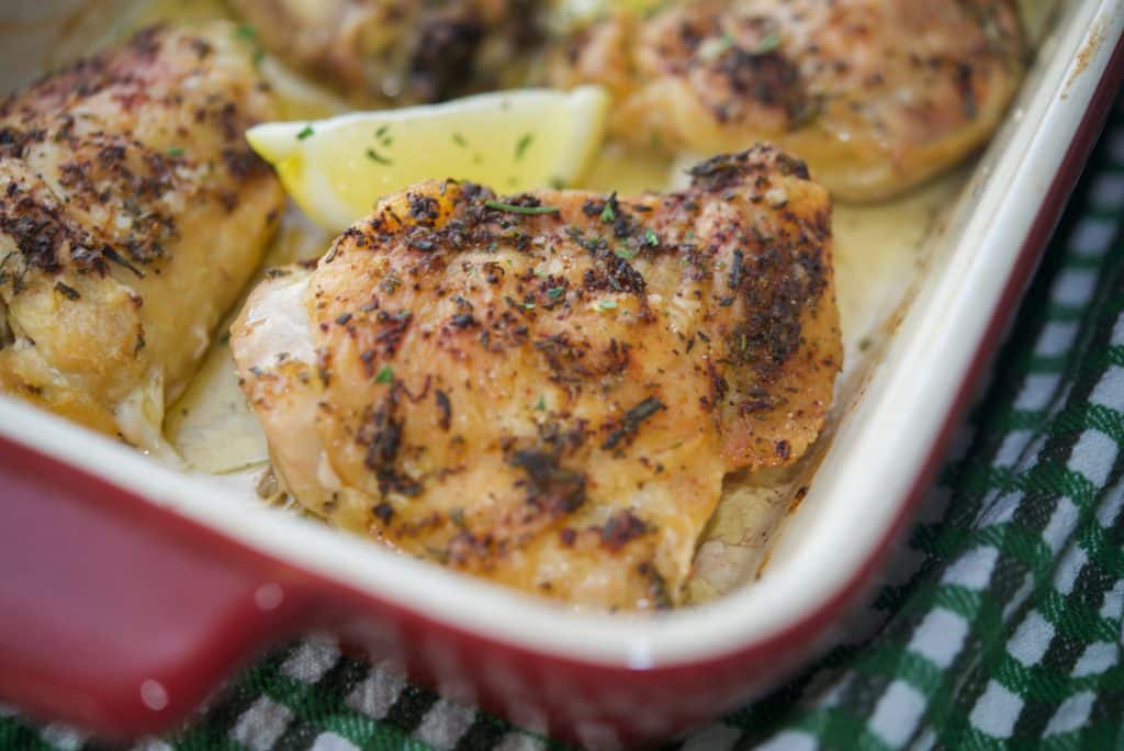 Rosemary & Lemon Roasted Chicken Thighs in red baking dish.