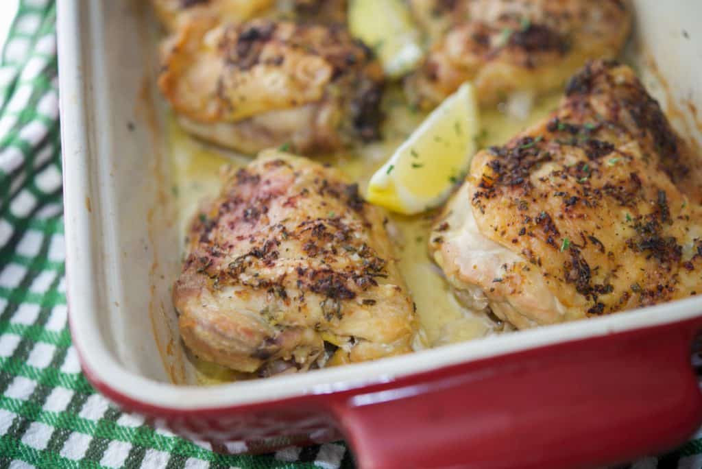 Roasted rosemary and lemon chicken thighs in baking dish.