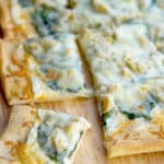 Spinach & Artichoke Flatbread made with spinach, artichoke hearts and a lemony, cheese sauce is perfect for pizza night or game day snacking. 