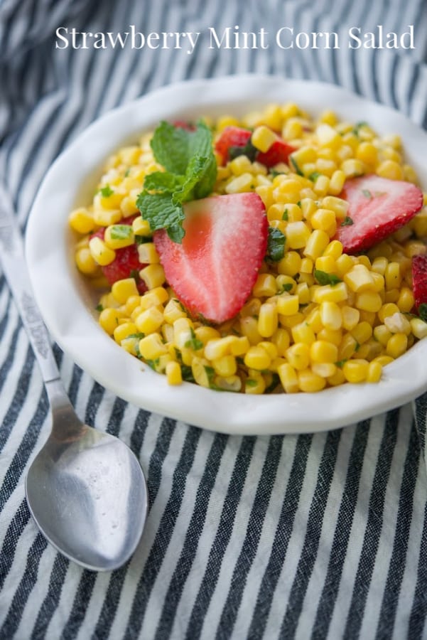 A bowl of food on a plate, with Corn and Salad