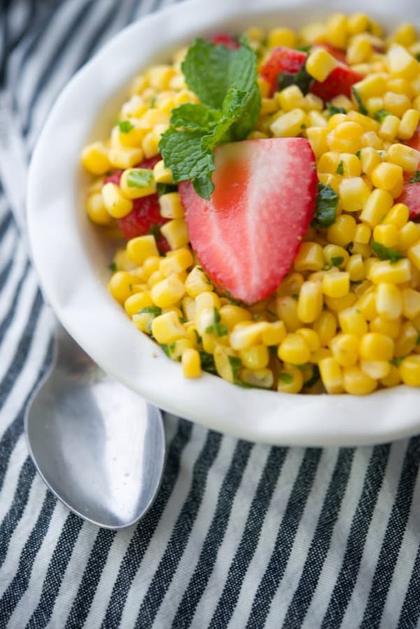 A close up of strawberry mint corn salad in a bowl. 