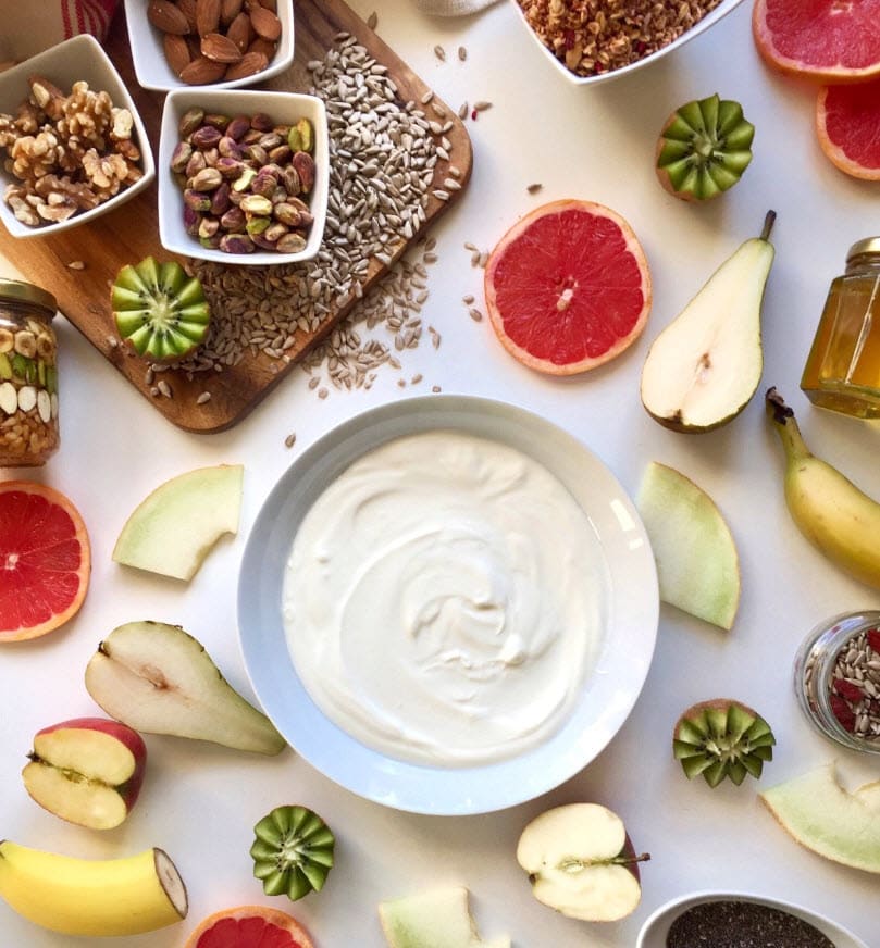 A table topped with different types of food on a plate, with Yogurt and Fruit