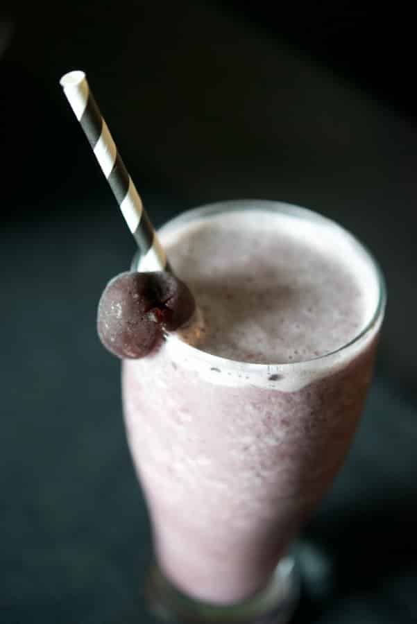 Cherry Almond Smoothie in glass with straw