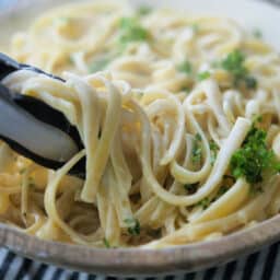 Fettuccine Alfredo in bowl with tongs