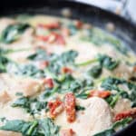 Creamy Tuscan Chicken made with boneless chicken pan seared in a skillet tossed with fresh spinach and sun dried tomatoes in an alfredo sauce.