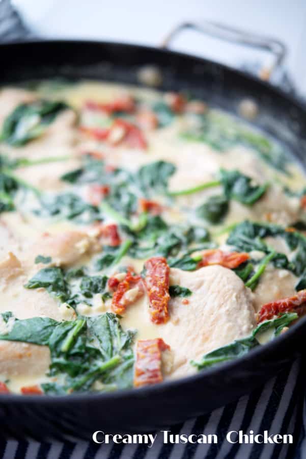 Creamy Tuscan Chicken made with boneless chicken pan seared in a skillet tossed with fresh spinach and sun dried tomatoes in an alfredo sauce. 