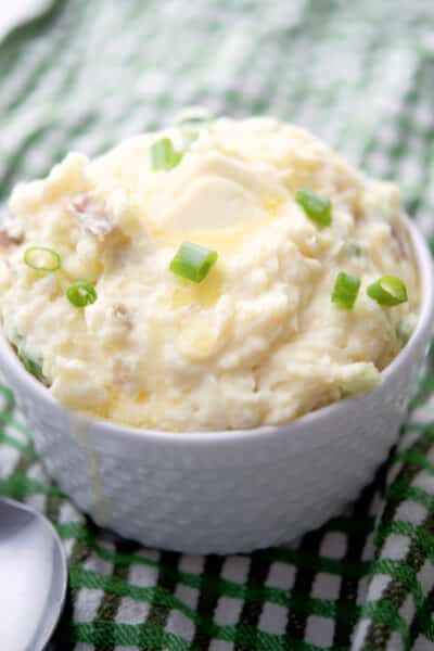 Havarti Red Bliss Mashed Potatoes with scallions in a white bowl.