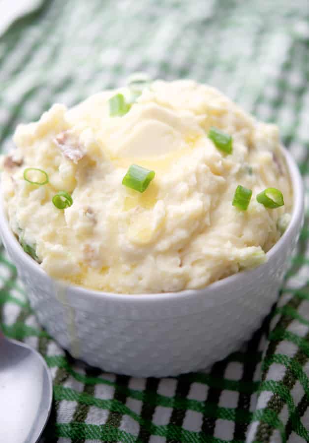 Havarti Red Bliss Mashed Potatoes with scallions in a white bowl.