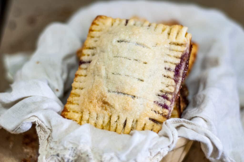 Mixed Berry Hand Pies in a basket with white napkin