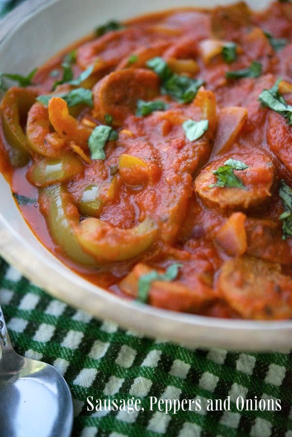 Sausage, Peppers and Onions in a red sauce in a serving bowl.