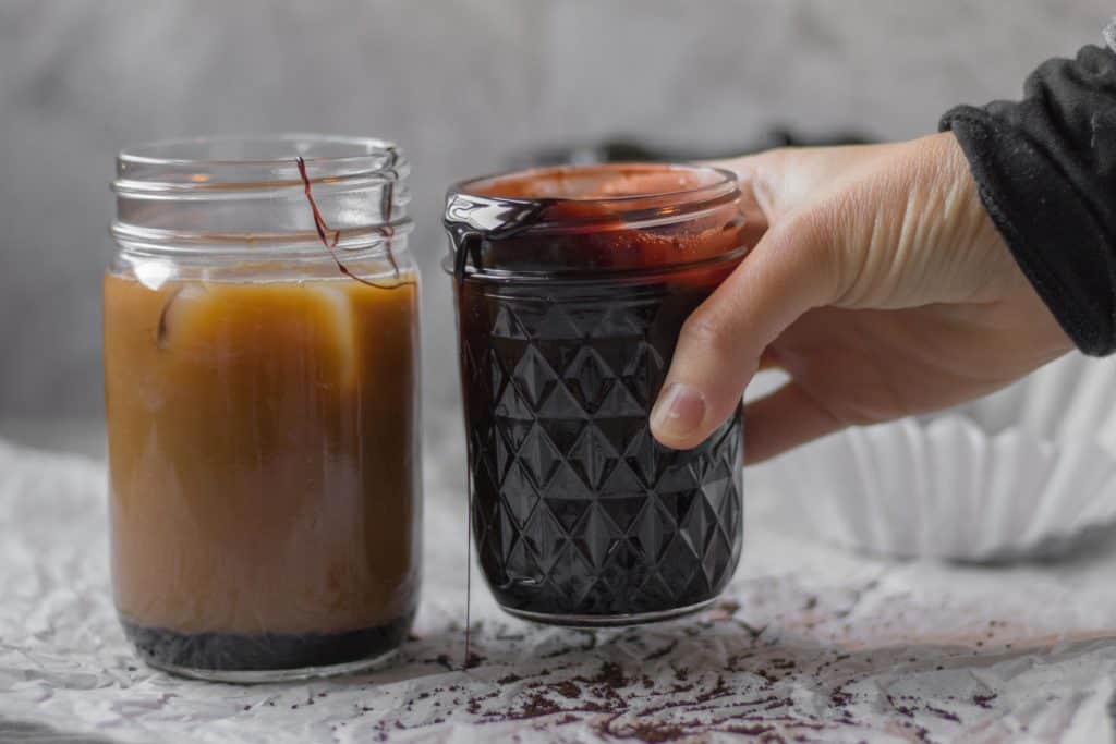 A glass cup on a table, with Iced mocha coffee