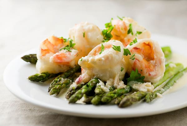 Chardonnay Shrimp on a bed of asparagus on a plate. 