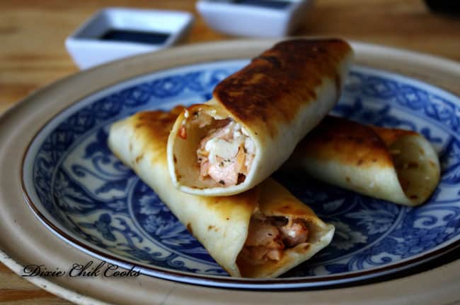 A plate of food on a table, with Salmon Taquitos 