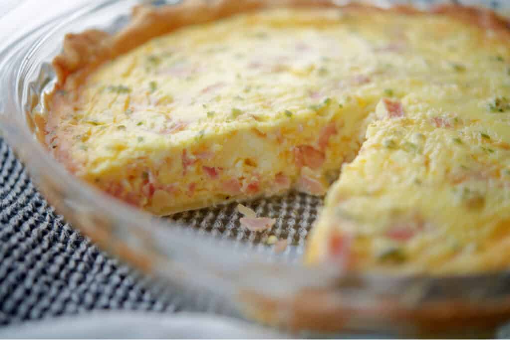 Ham and Cheese Quiche with chives in a pie plate