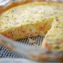 Ham and Cheese Quiche with chives in a pie plate