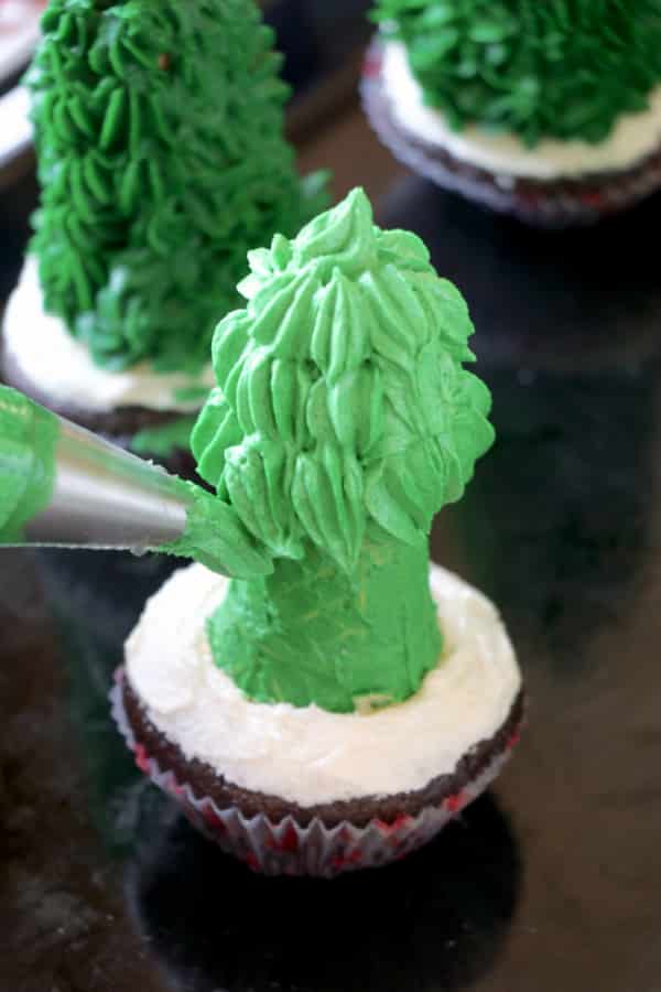 Adding green icing to the tree cupcakes