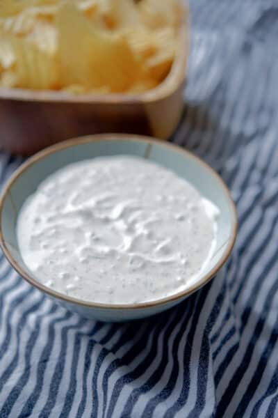 Onion Dill Dip with potato chips in a bowl