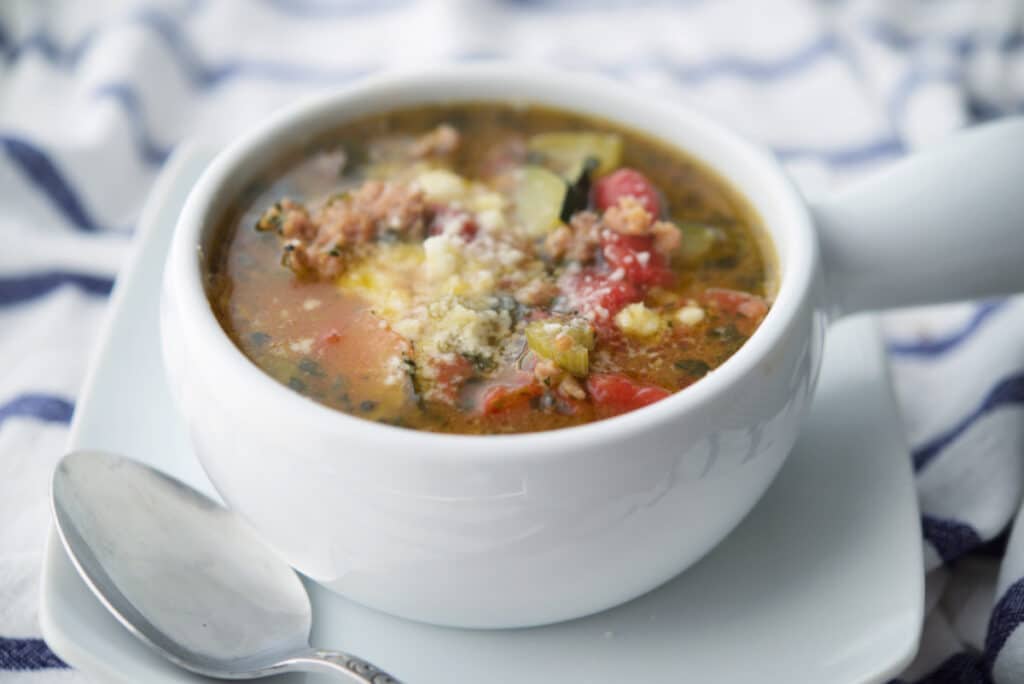Sausage and Zucchini Soup in white crock