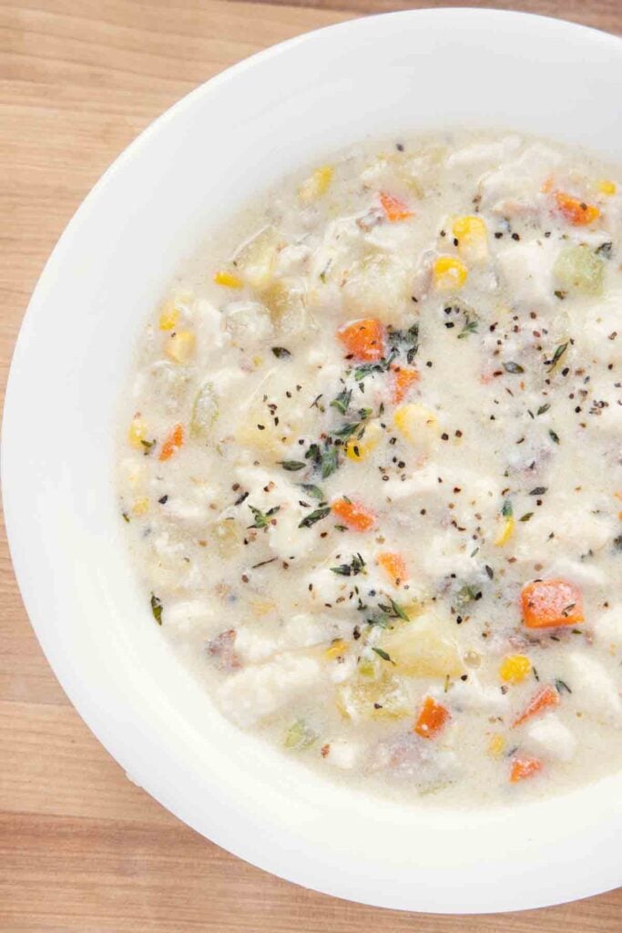 A bowl of food on a plate, with Chowder and Fried tilapia