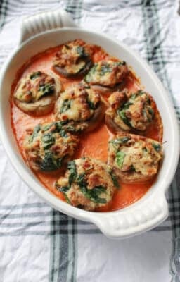 Four Cheese and Sausage Stuffed Mushrooms in a white dish
