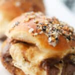 Thinly sliced roast beef, topped with fresh Mozzarella cheese and brown gravy on top of a slider roll garnished with a buttery, Everything Bagel seasoning.