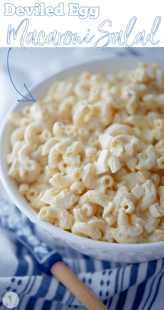 Deviled Egg Macaroni Salad in white bowl with spoon and name on photo.