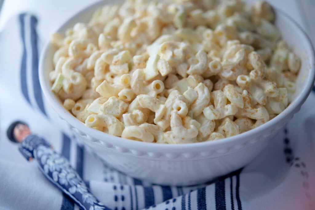 Deviled Egg Macaroni Salad in a bowl with serving spoon.