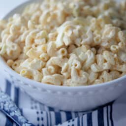 Deviled Egg Macaroni Salad in a bowl with serving spoon.