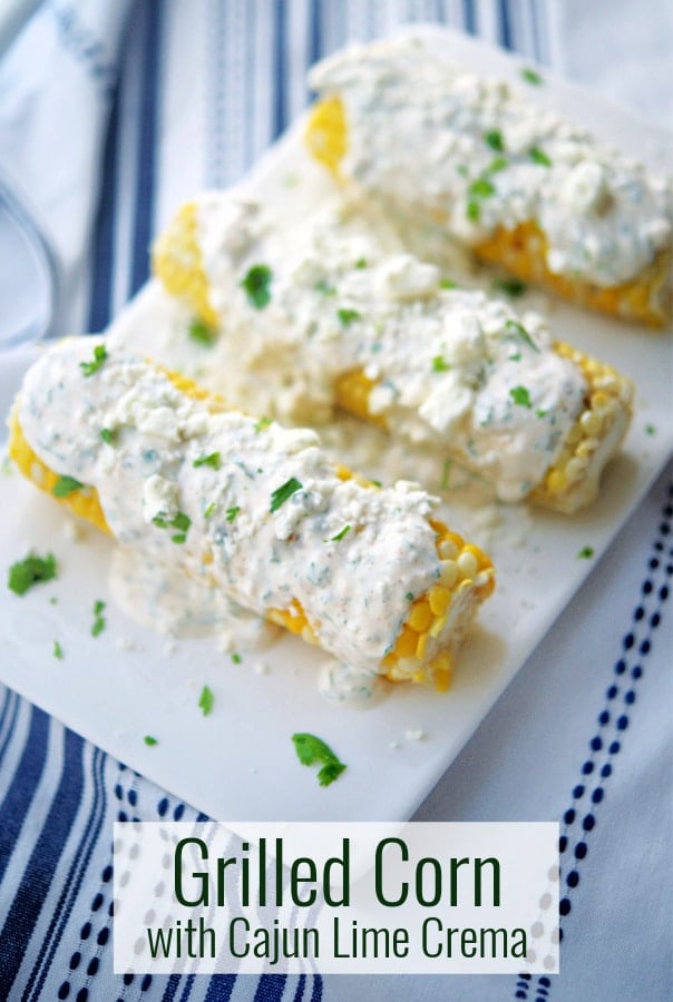 Corn on the cob on a plate with cajun lime crema.