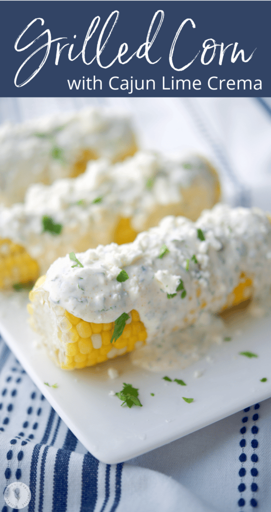 Grilled corn on a white serving platter with cajun lime crema.