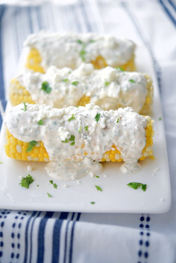 Grilled Corn with Cajun Lime Crema on a white serving platter. 