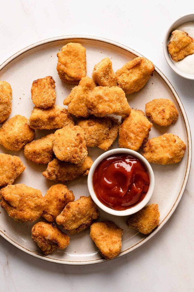 air fryer chicken nuggets on a plate with ketchup