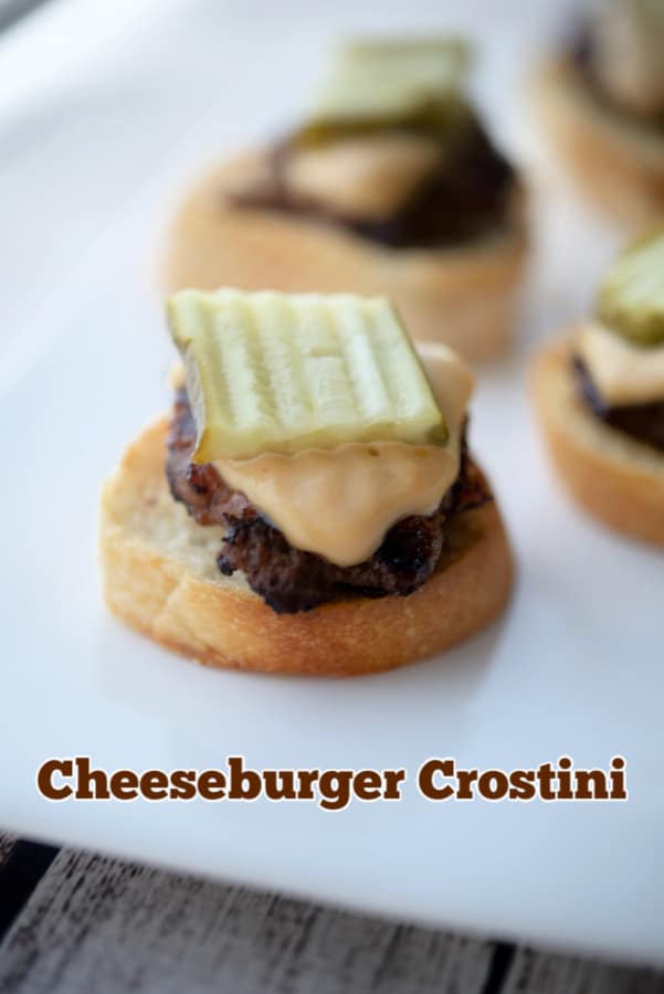 A close up of cheeseburger crostini on a white plate.