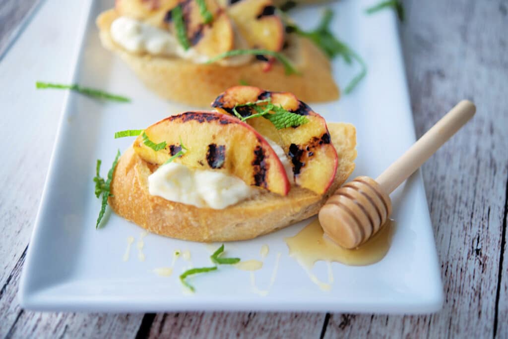 A close up of peaches on bread on a plate. 