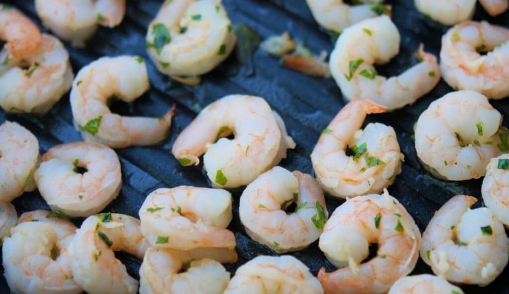 A close up of cooked shrimp on a grill pan
