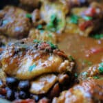 A close up of Mexican chicken with black beans in a skillet