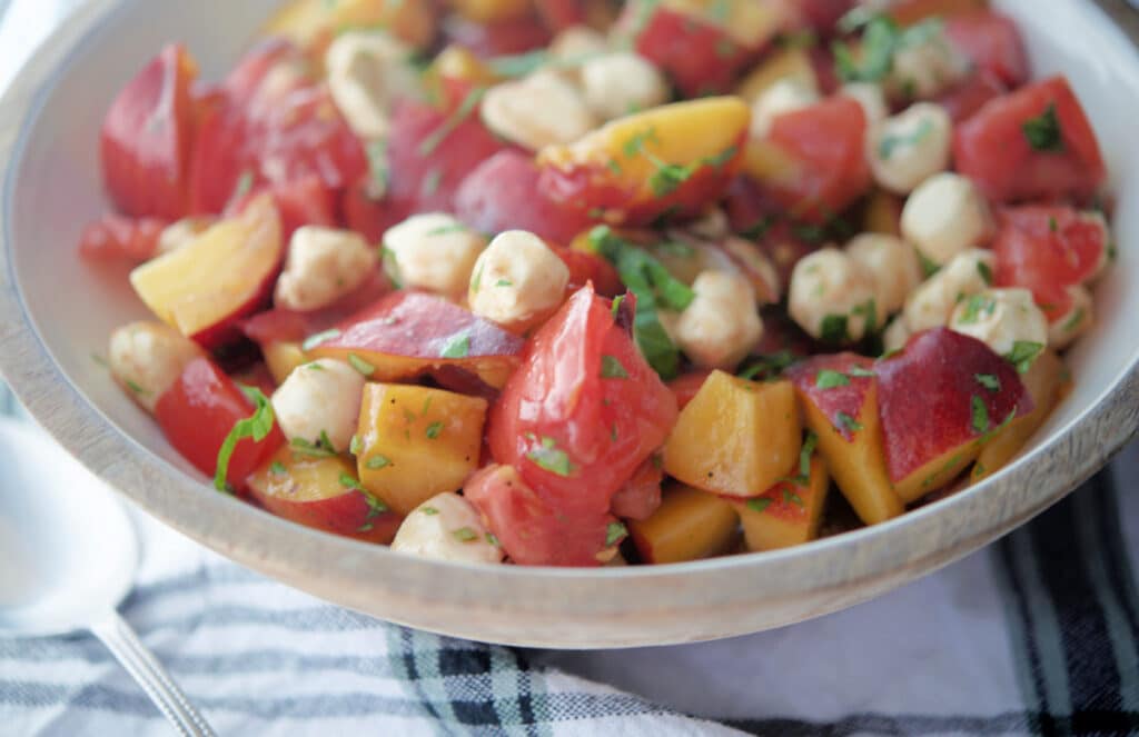 A close up of peach, tomato and mozzarella salad