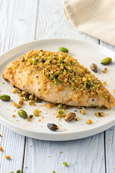 a plate with a piece of pistachio baked chicken