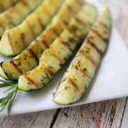 Zucchini wedges grilled on a white plate.