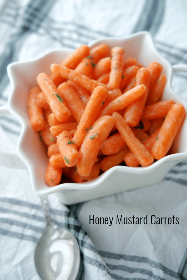 Baby carrots in a white square dish. 
