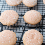 Lemon cookies that are pink on a cooling rack.