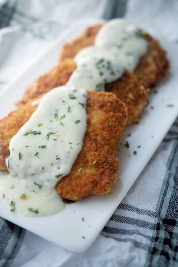 Pork Scaloppine with lemon sauce on a white plate