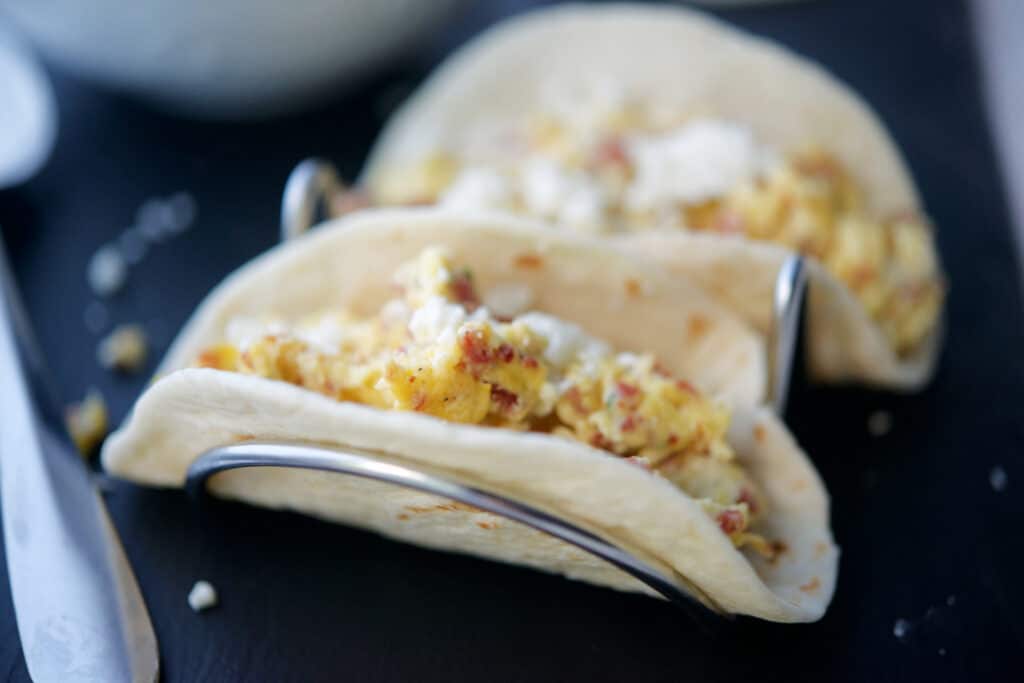 A close up of breakfast tacos on a taco stand