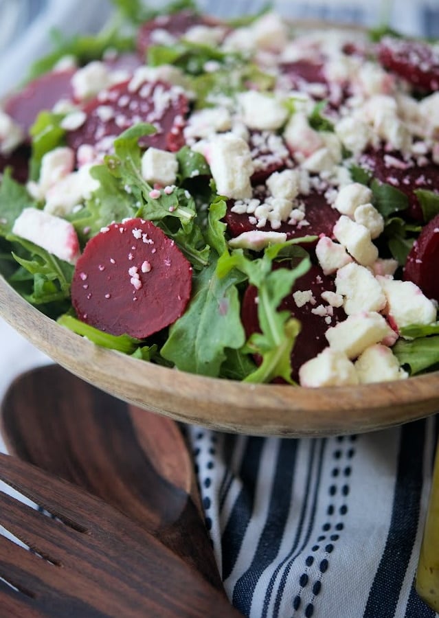 Arugula with beets and feta in a wooden salad bowl. 