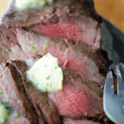 A close up of sliced steak with butter.