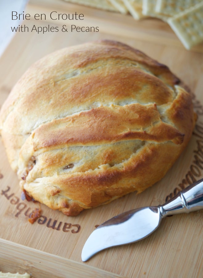 Brie cheese wrapped in crescent dough on a cutting board