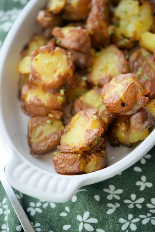 Potatoes with chive butter in a white dish. 